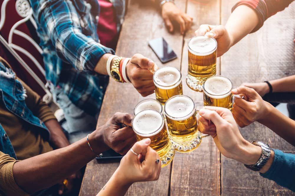 Group toasting with beer mugs during the Vegas Buds & Brews Tour, featuring visits to top dispensaries and a local brewery.